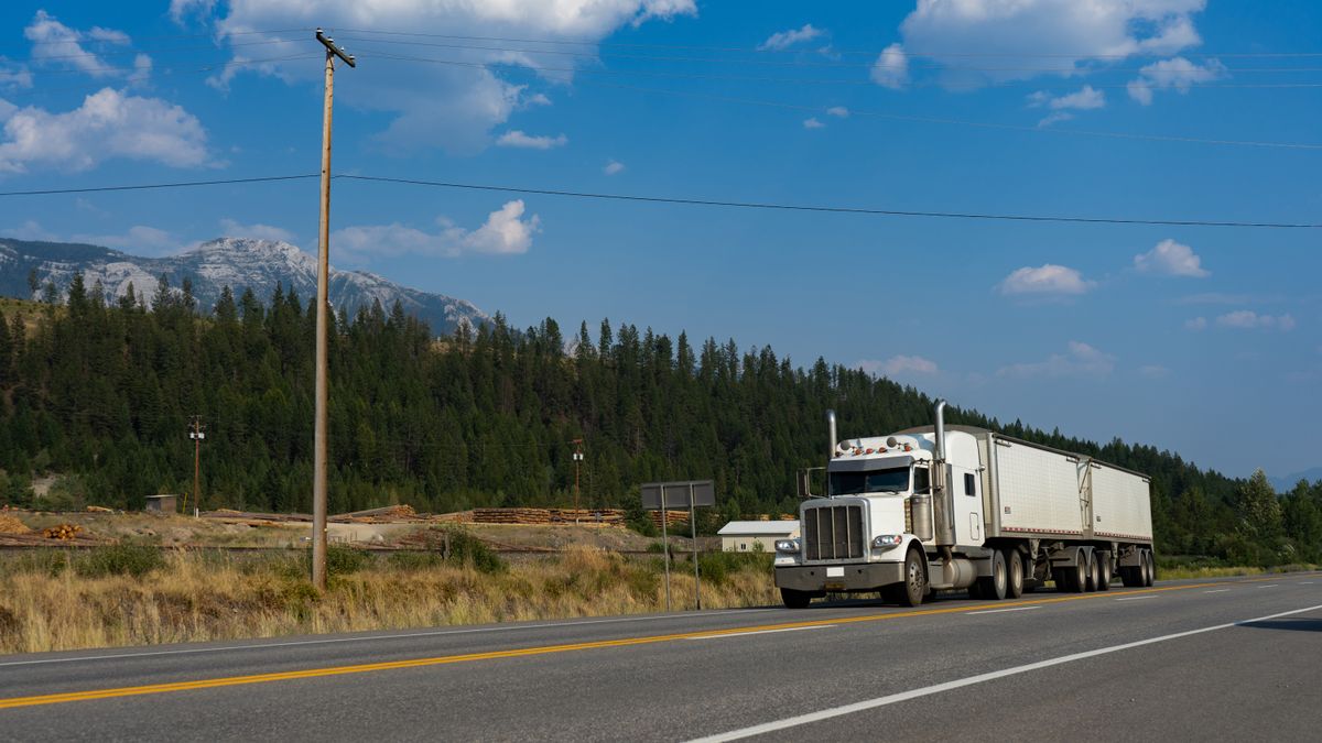 White semi-truck on a scenic mountain highway
