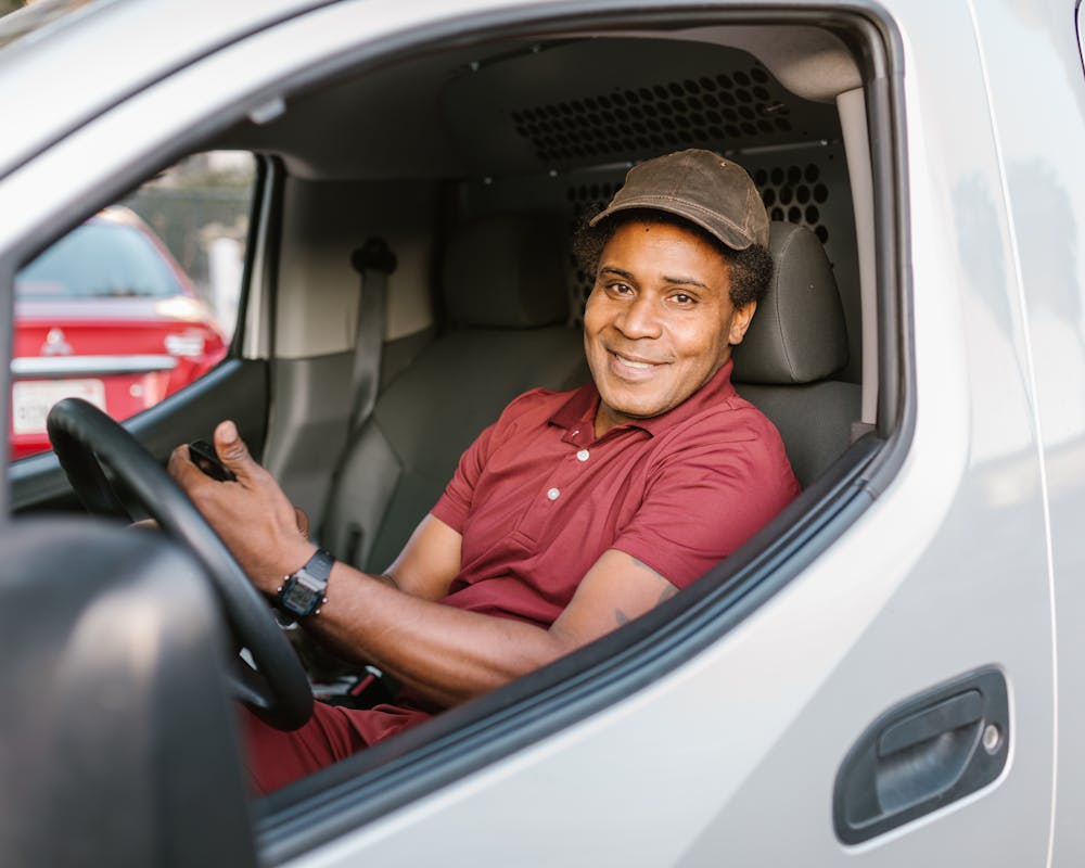 Conductor comercial sonriente en la cabina de una camioneta