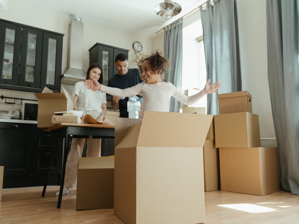 Familia feliz desempacando cajas de mudanza en una casa nueva y luminosa