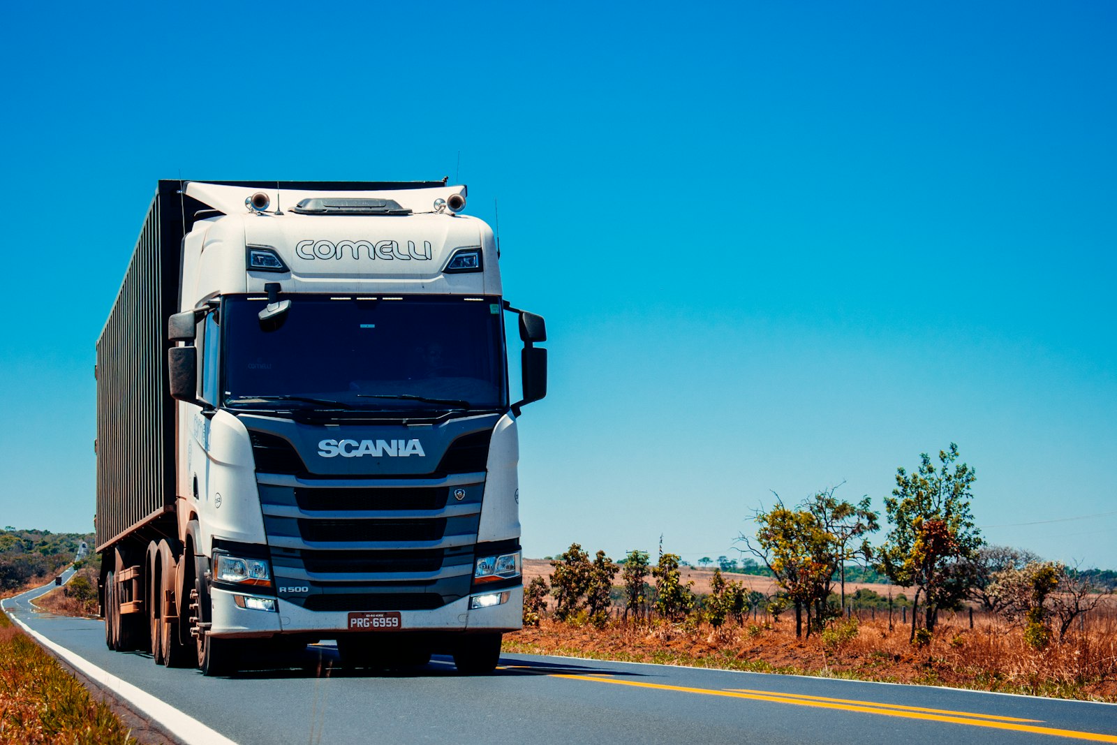 Camiones comerciales en una carretera arbolada